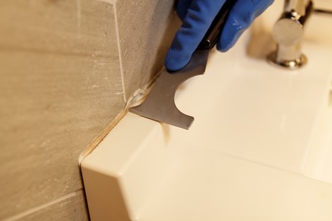 scrape away softened caulk